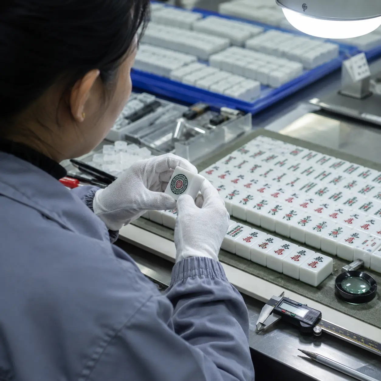 HUHU Mahjong quality control inspection showing workers checking tile details with professional measuring tools