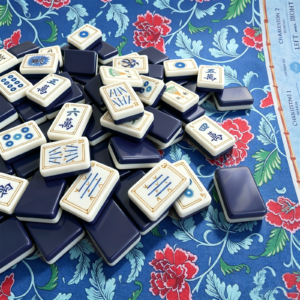 Sapphire Trail ivory and blue acrylic Mahjong tiles displayed on a floral mat